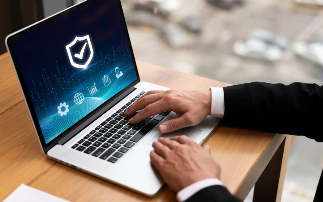 A person in a business suit using a laptop displaying a cyber security shield icon.